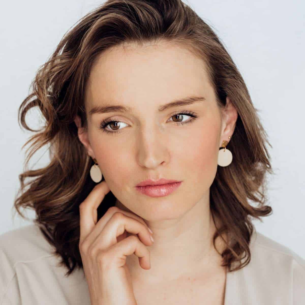 Elegante Frau mit braunen Haaren und weißen Ohrringen, christliche Lifestyle-Model.