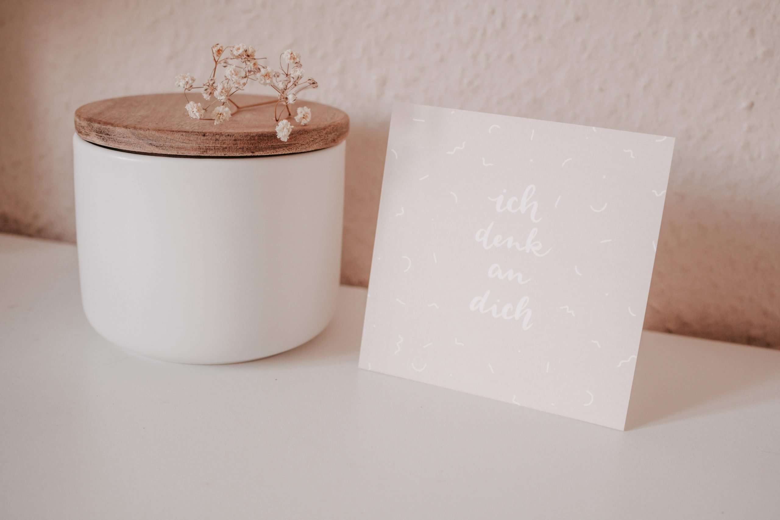 Stumpenkerze mit Holzdeckel und Bibelverskarten als christliche Dekoration.