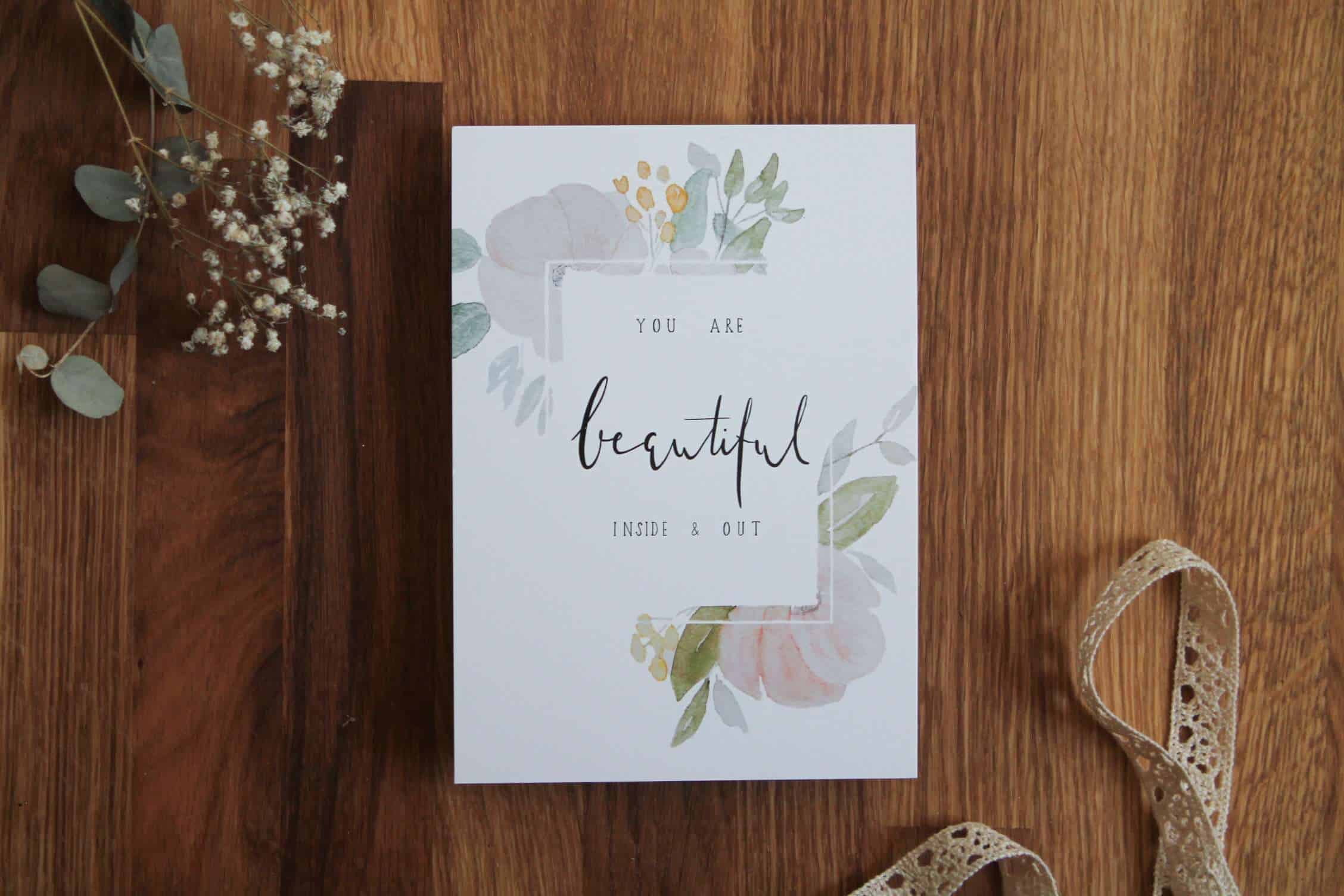 Schöne christliche Grußkarte mit Blumenmotiven auf Holztisch.