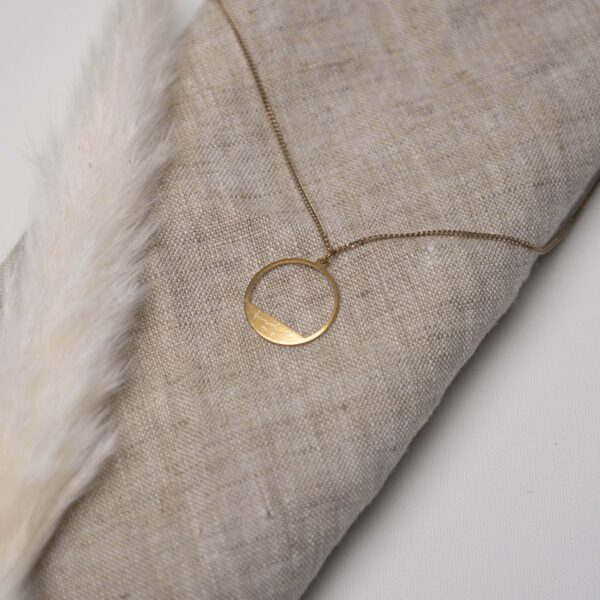 Elegantes christliches Schmuckstück mit graviertem Kreuzanhänger auf Leinenstoff.