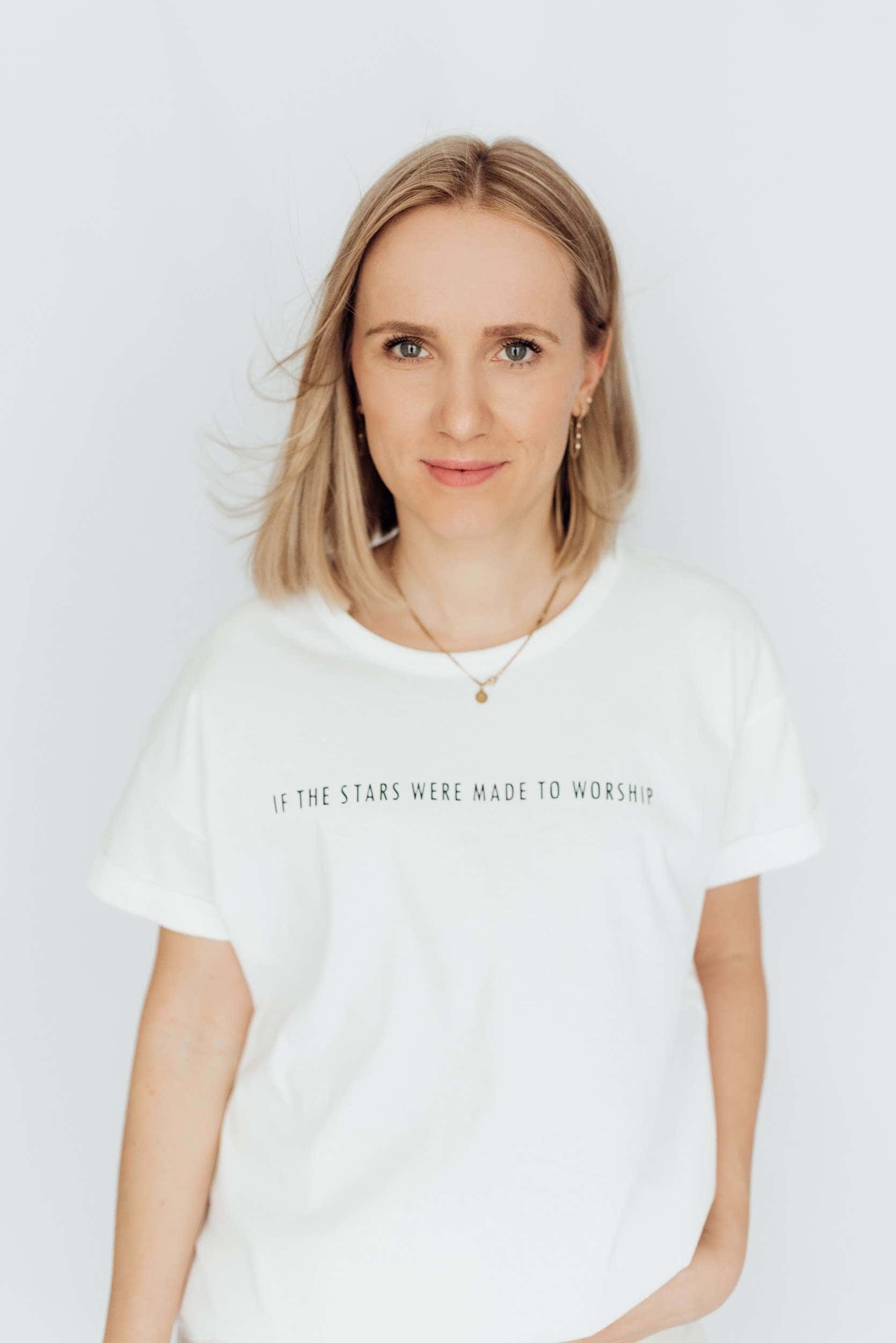 Hübsche Frau trägt T-Shirt mit christlichem Spruch auf weißem Hintergrund.