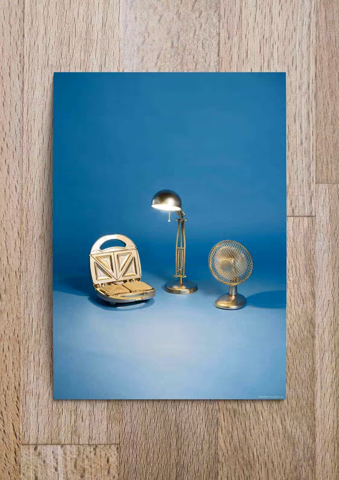 Kunststoff-Nachbildungen von Haushaltsgeräten auf blauer Hintergrundlandschaft.