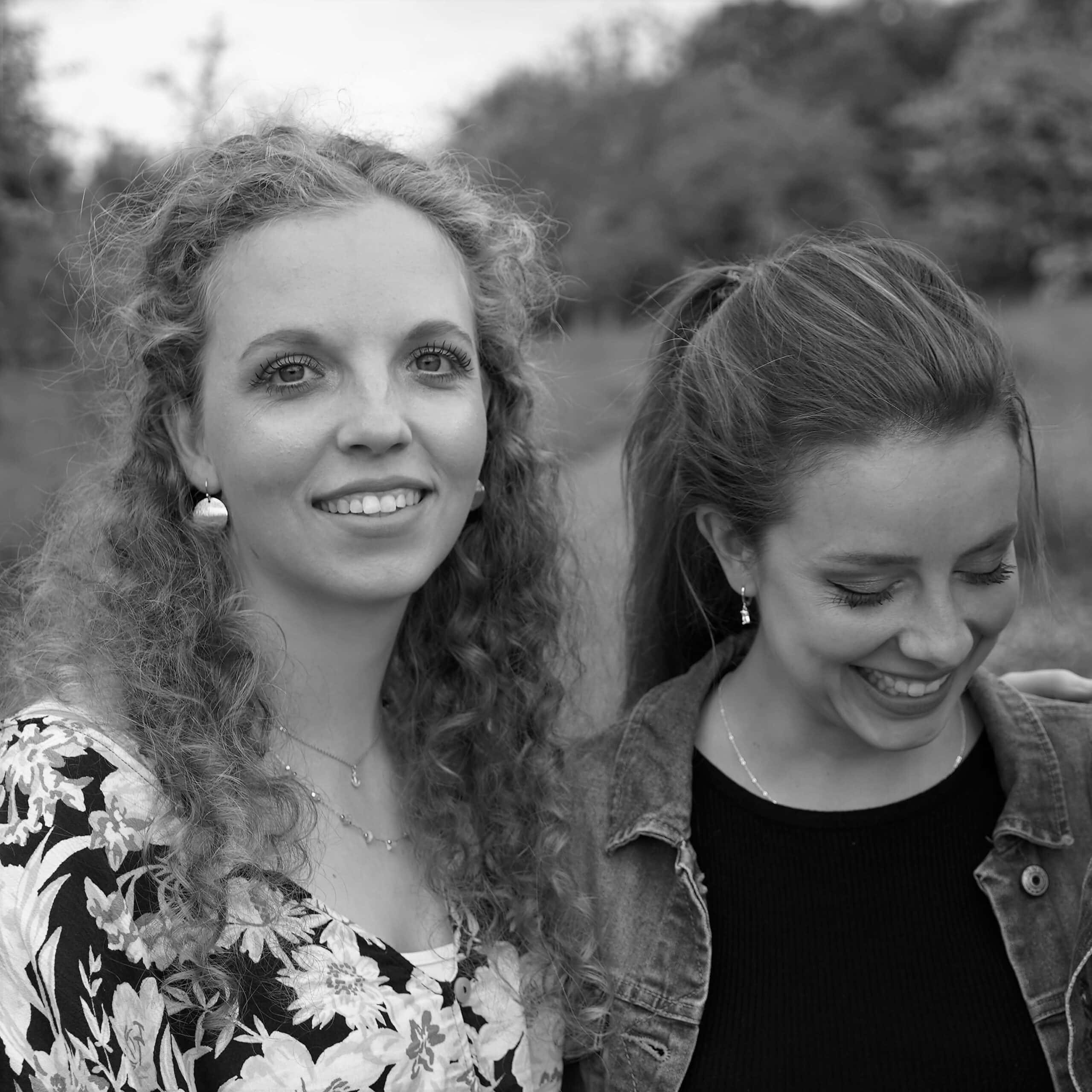 Freundinnen mit christlichem Glauben, lachend und entspannt im Freien.