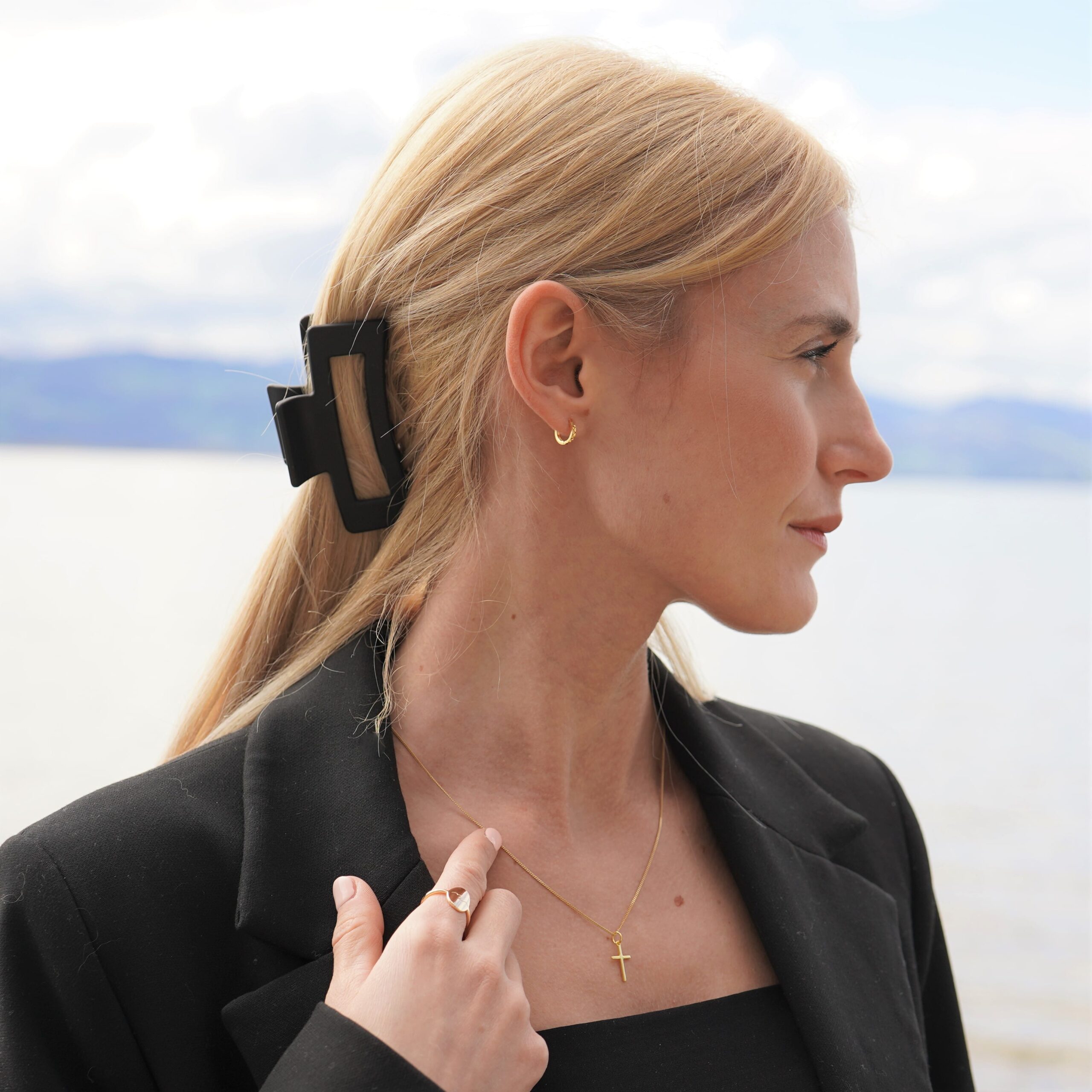 Die christlichen Ohrringe Hoop GLORY von FIRSTGOD und mookho, getragen von einer jungen Frau. Seitliche Perspektive.