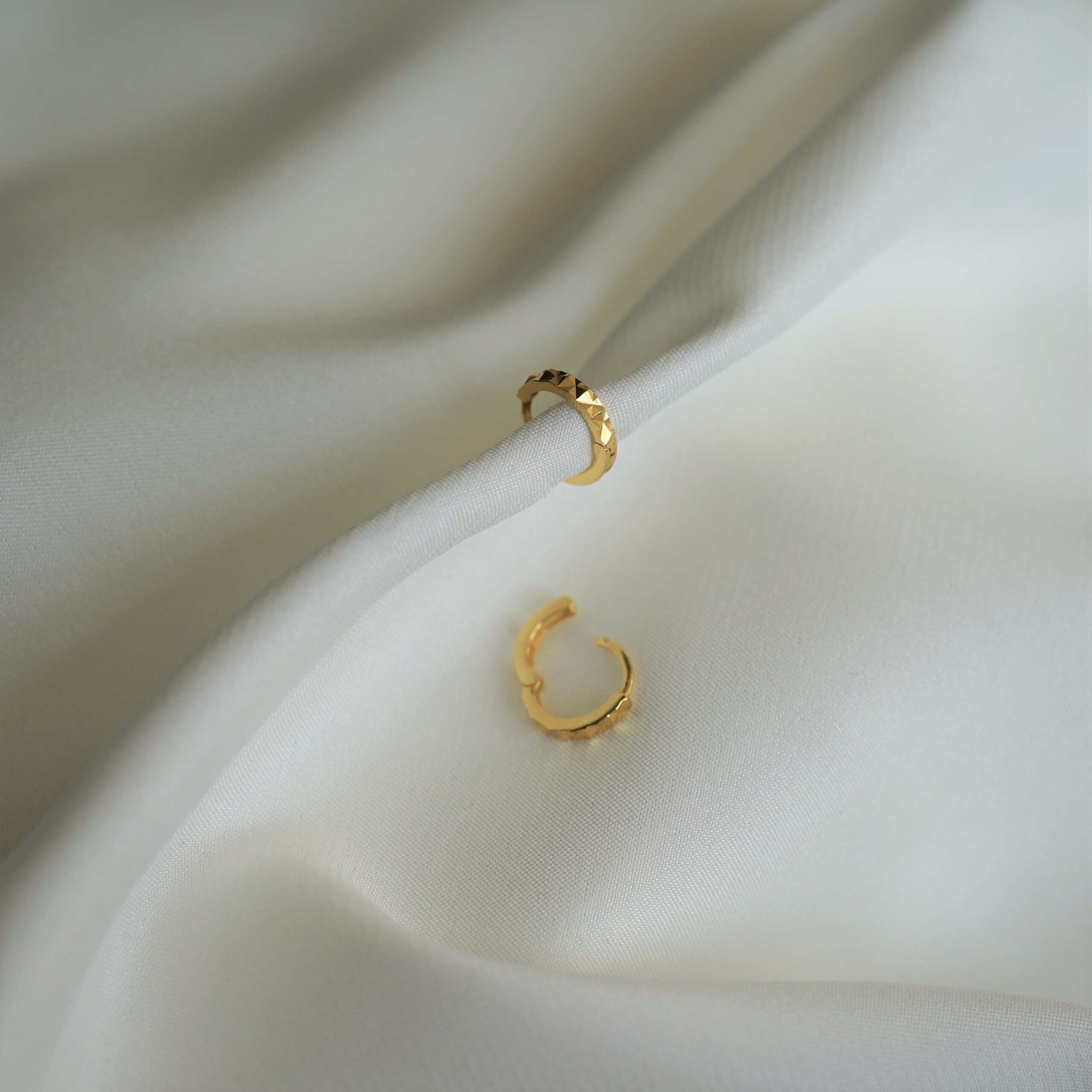 Goldohrringe mit Textur, elegante Accessoires für christlichen Stil.