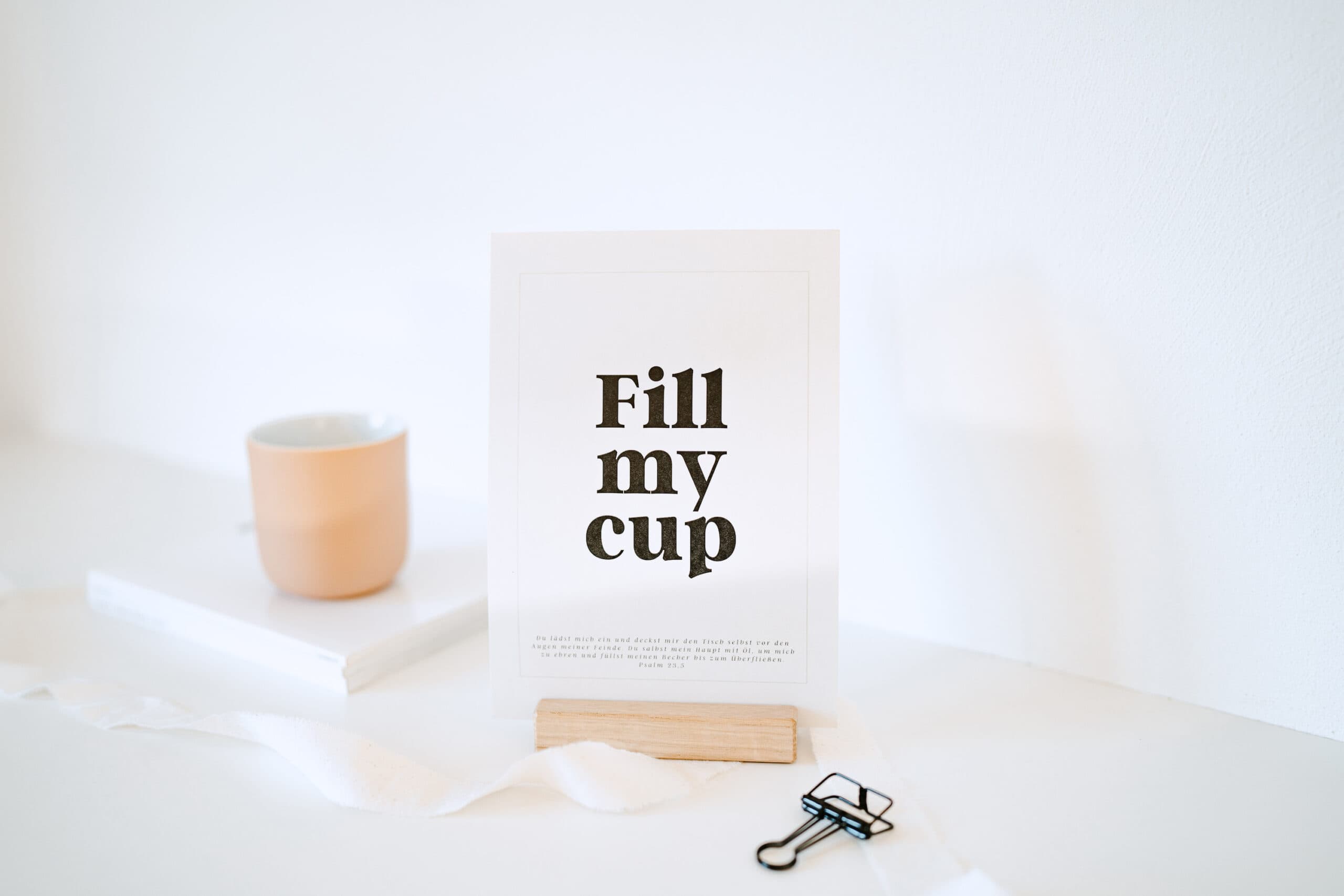 Moderner Christlicher Beistelltisch mit Keramikbecher und Gebetskarte.