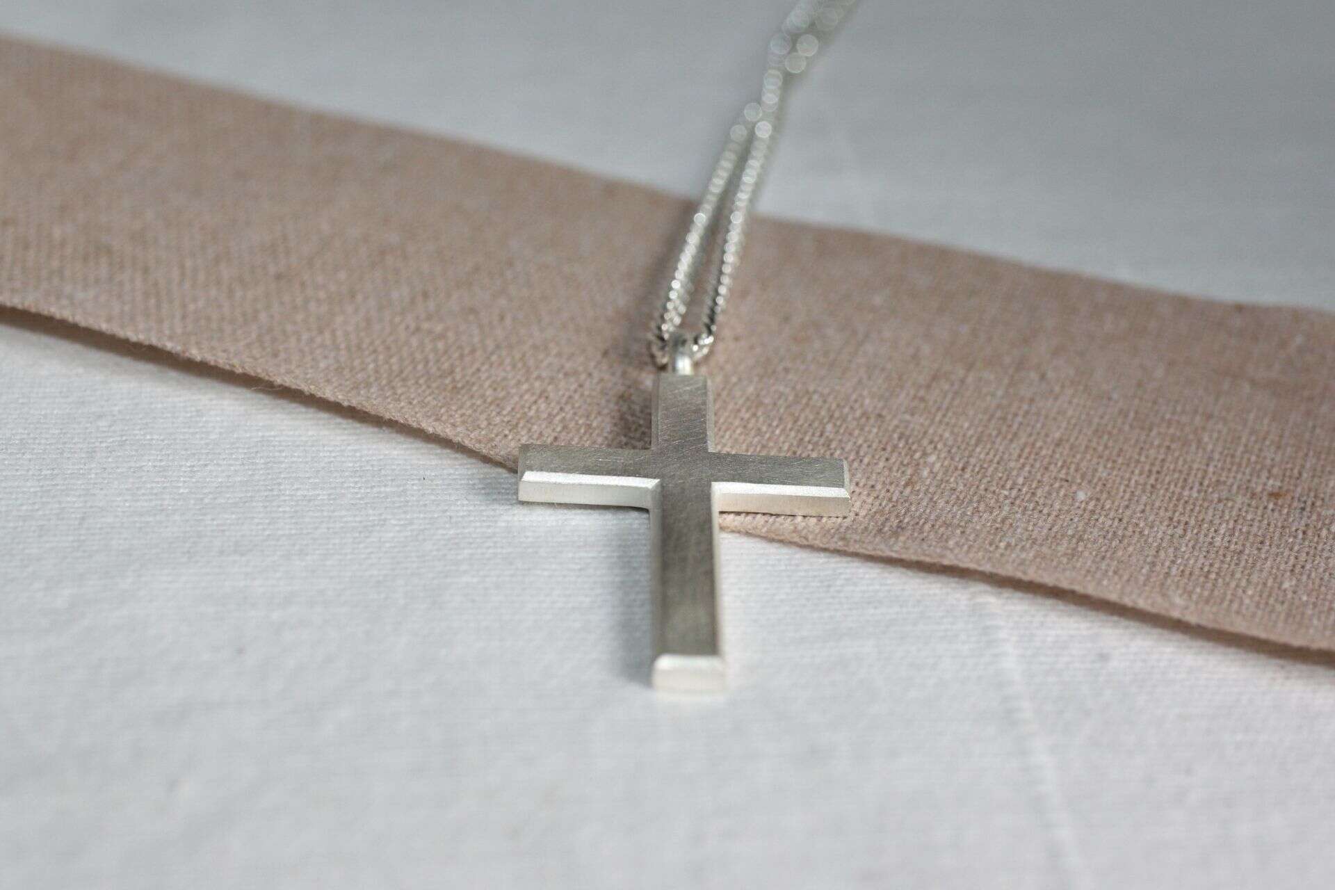Moderner Silberschmuck mit Kreuzanhänger, christliches Schmuckdesign.