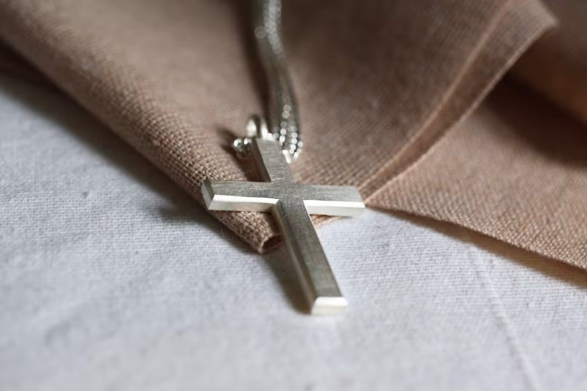 Halskette mit Kruzifix, christliches Schmuckstück, religiöser Schmuck, Glaube, Andacht.