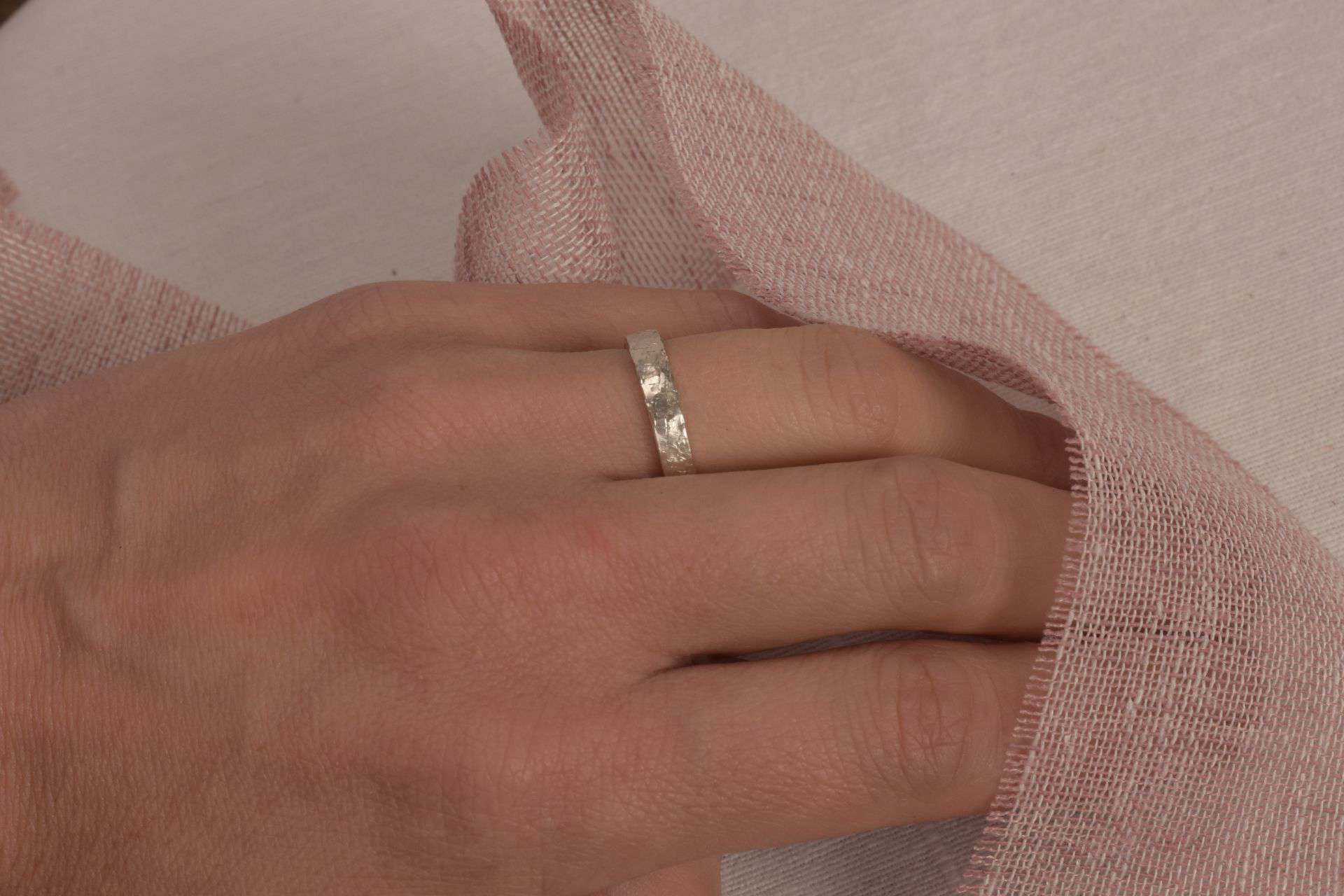 Moderner Silberring auf weiblicher Hand, Nahaufnahme, Schmuck für Christen, elegante Accessoires.