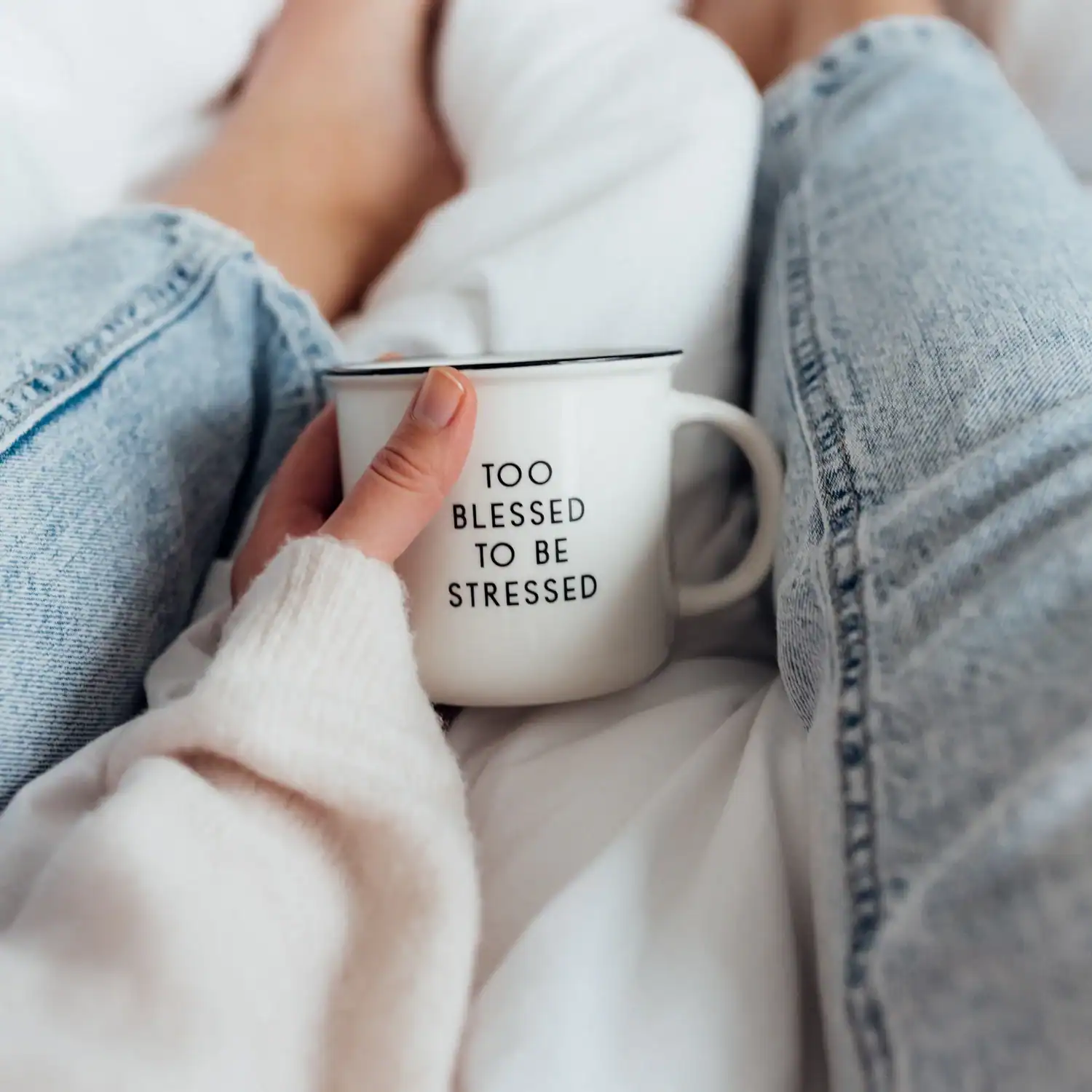 Becher mit christlicher Botschaft "Too blessed to be stressed" auf gemütlicher Couch.