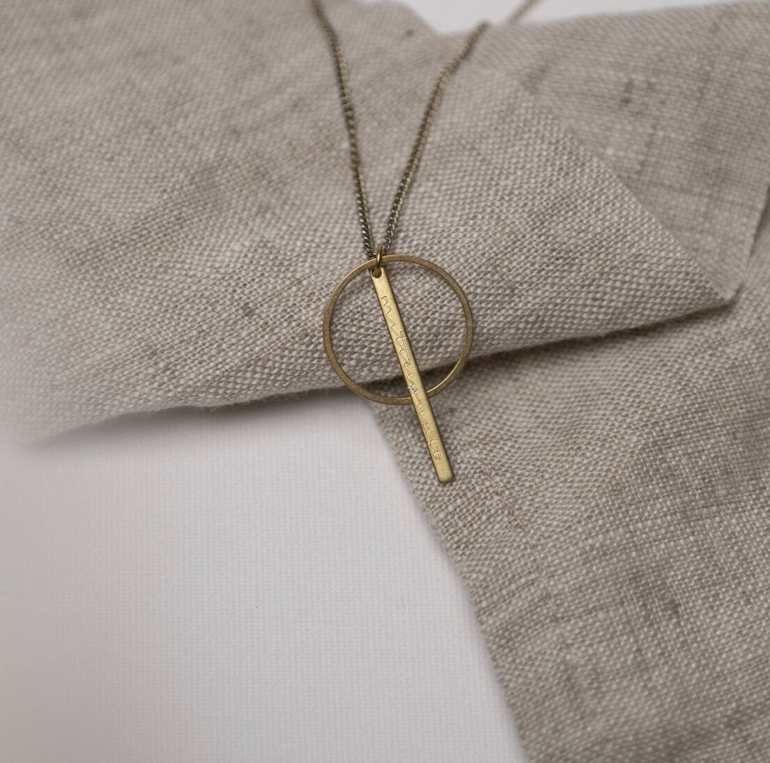 Moderner goldener Kreuzanhänger mit Schriftzug auf Kette, christliche Schmuckstücke.