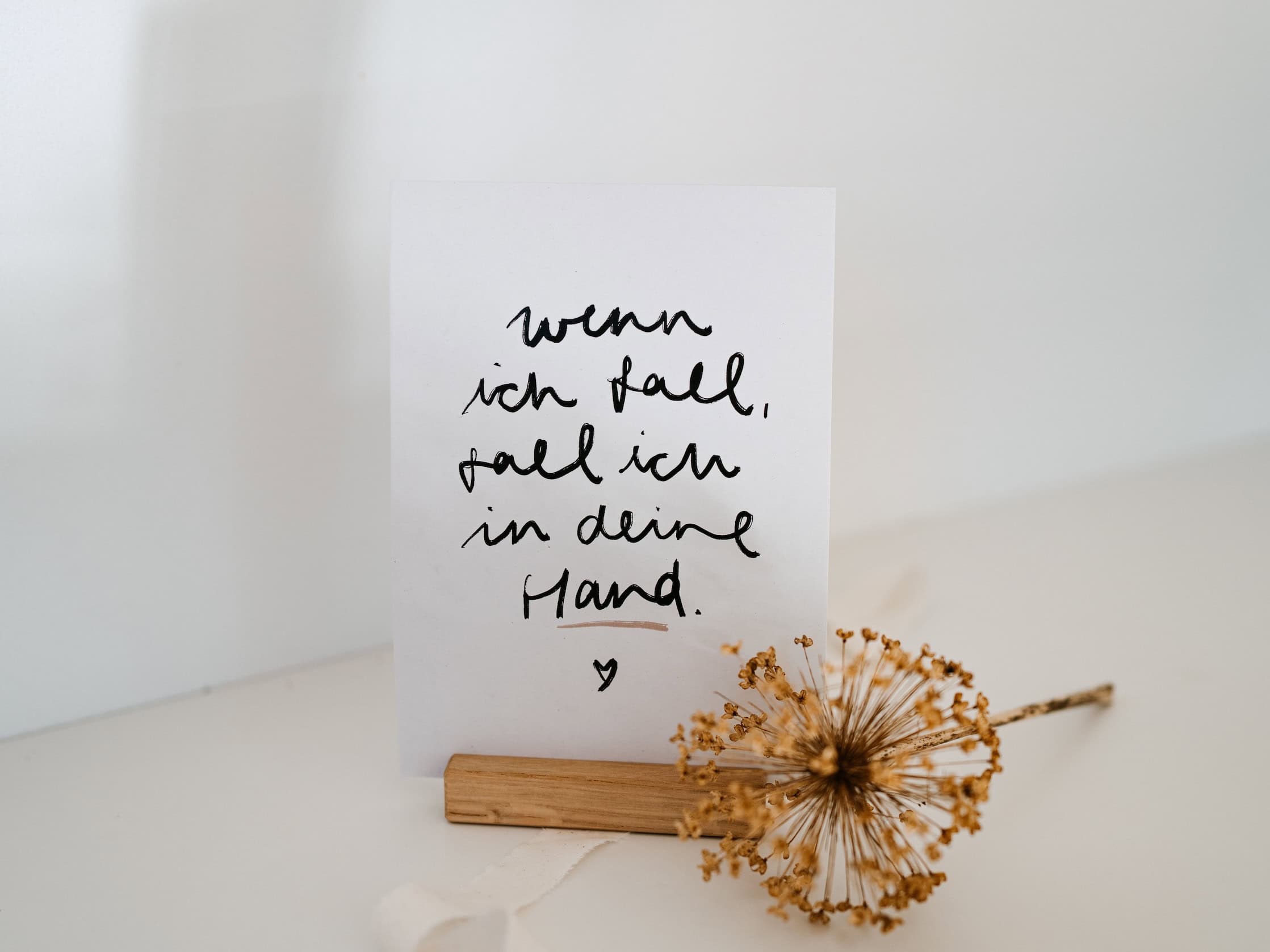 Inspirierende christliche Zitate auf handgeschriebenem Papier, Deko mit Trockenblume.