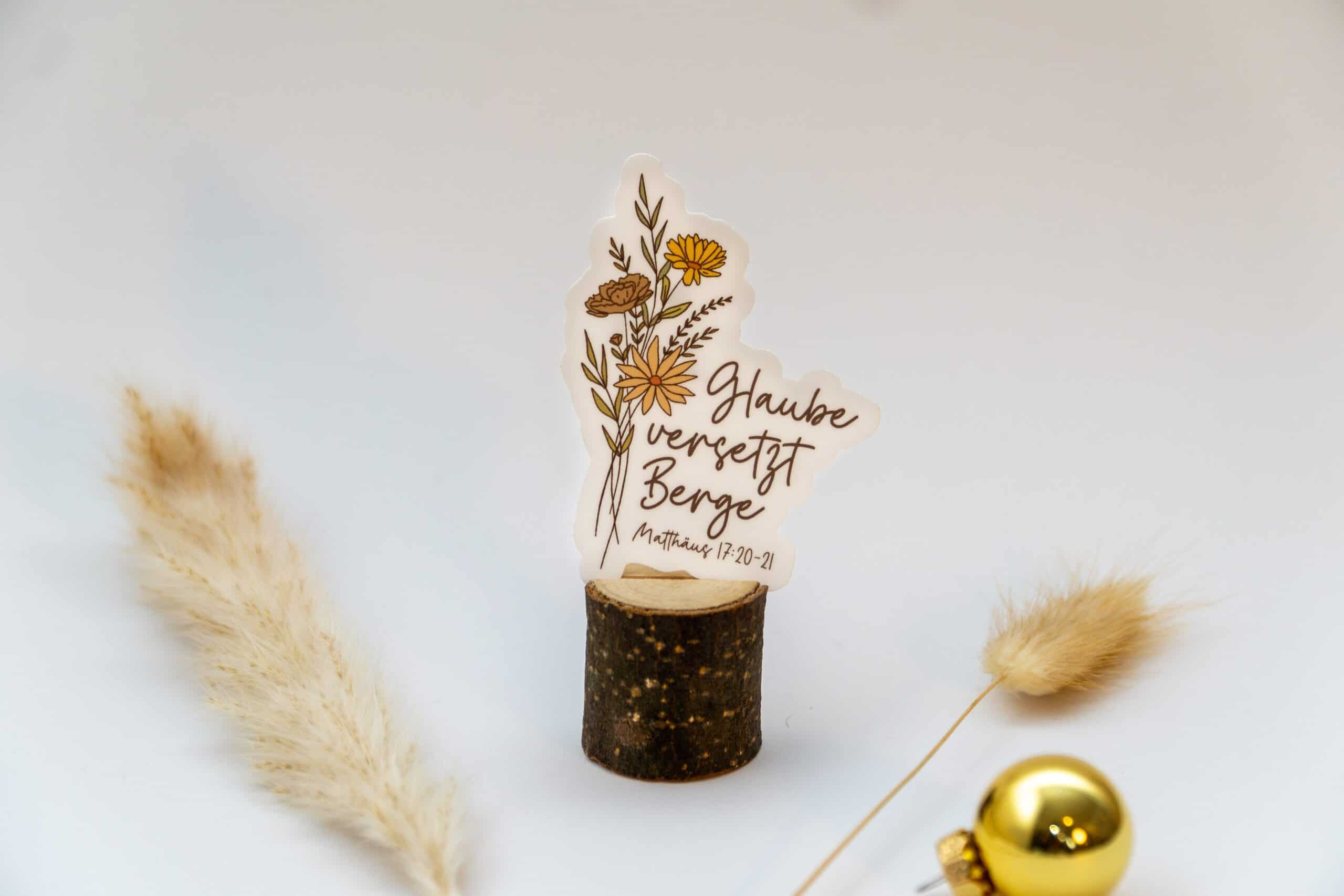 Blumen mit Bibelvers auf Holzstück, christliche Deko, Glaubenssymbol, Gebetsbotschaft.