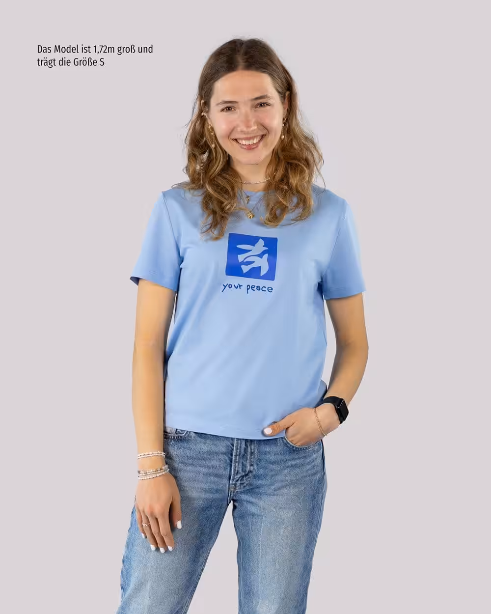 Begeisterte junge Frau trägt christliches T-Shirt mit Friedenssymbol, Mode & Glaube.