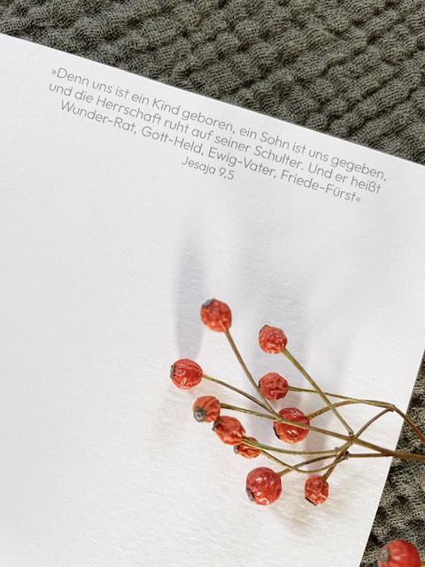 Fröbelsterne mit christlichem Bibelvers auf weißem Papier, christliche Weihnachtsdekoration.