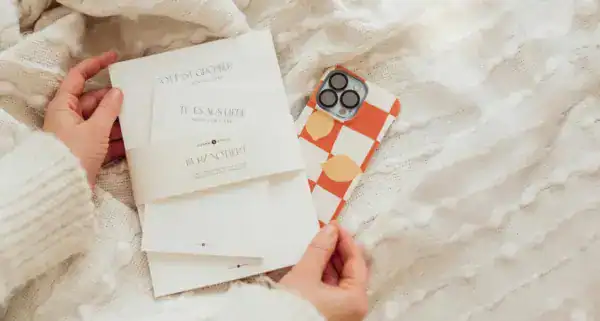 Notizblock, Schriftstücke und Smartphone auf weißem gestricktem Stoff, christliche Marken, kreative Notizen.