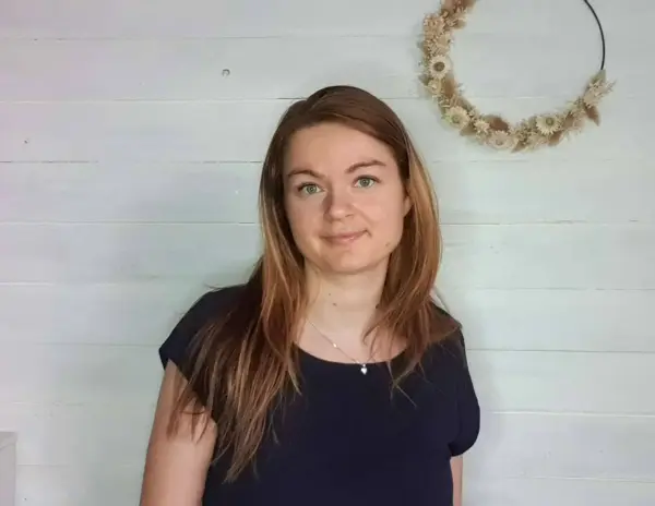 Hübsches Portrait einer Frau mit roten Haaren vor weißem Holz-Hintergrund.