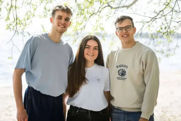 Fröhliche Freunde am Strand unter einem Baum, entspanntes Sommerfoto, Lifestyle, Freizeit, Natur, Urlaub.