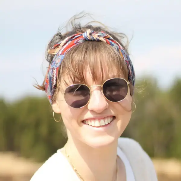 Farbenfrohe Frau mit Sonnenbrille und Bandana, sommerliches Stylebild.