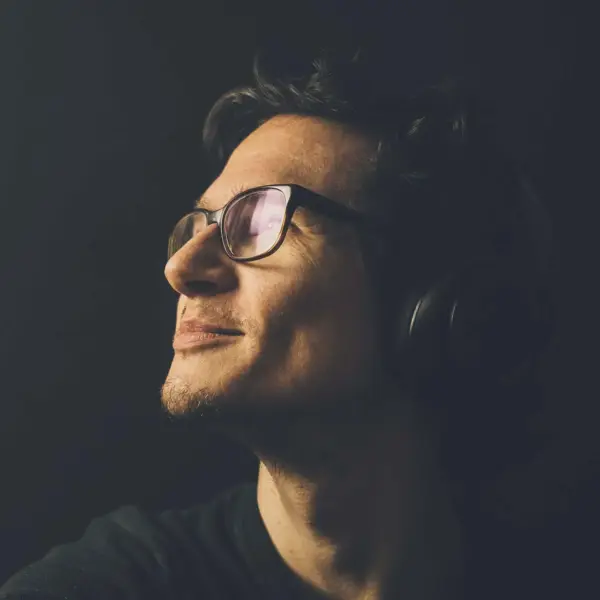 Stylischer junger Mann trägt Sonnenbrille und Kopfhörer, Musikliebhaber, Lifestyle-Foto.