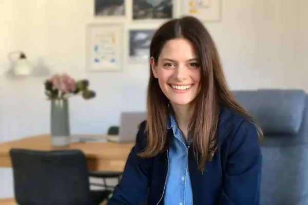 Hochwertiges Bild einer lächelnden jungen Frau in einem modernen Büro.